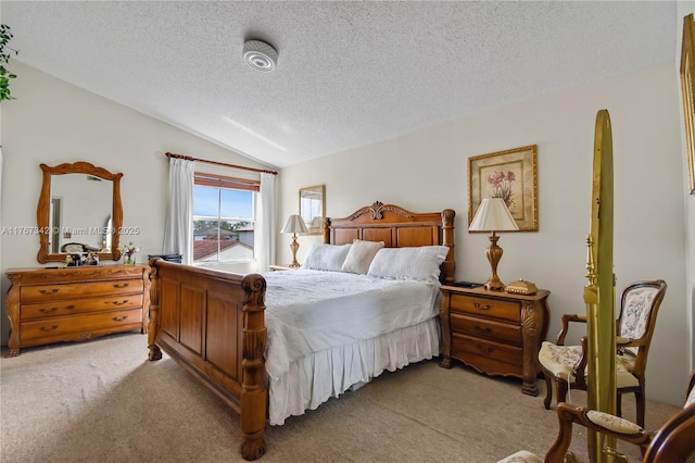 carpeted bedroom featuring a textured ceiling and lofted ceiling