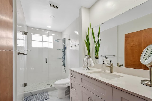 bathroom featuring vanity, a stall shower, toilet, and visible vents