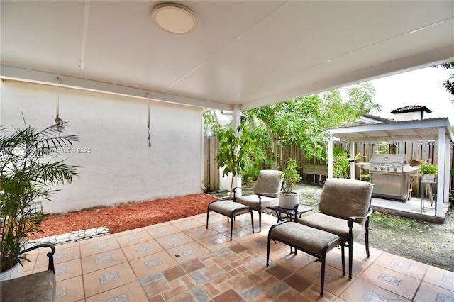 view of patio with fence and a grill