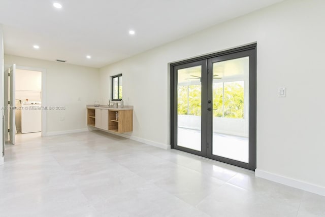 empty room with recessed lighting, french doors, plenty of natural light, and washer / dryer