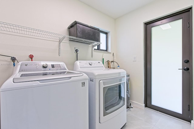 laundry room featuring light tile patterned floors, laundry area, and washing machine and clothes dryer