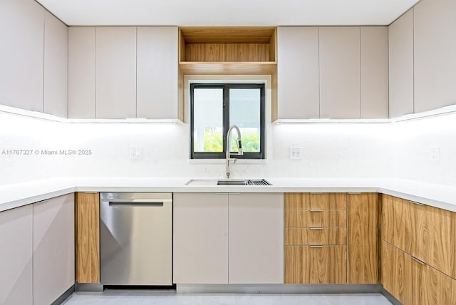 kitchen featuring stainless steel dishwasher, modern cabinets, light countertops, and a sink