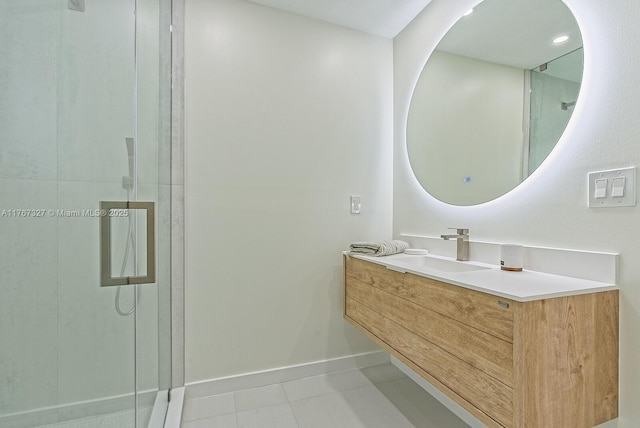 bathroom featuring vanity, a shower stall, baseboards, and tile patterned floors