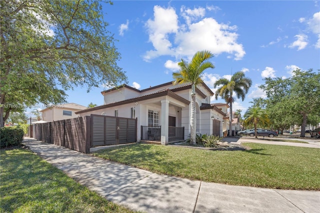 mediterranean / spanish-style house featuring a fenced front yard, stucco siding, and a front yard