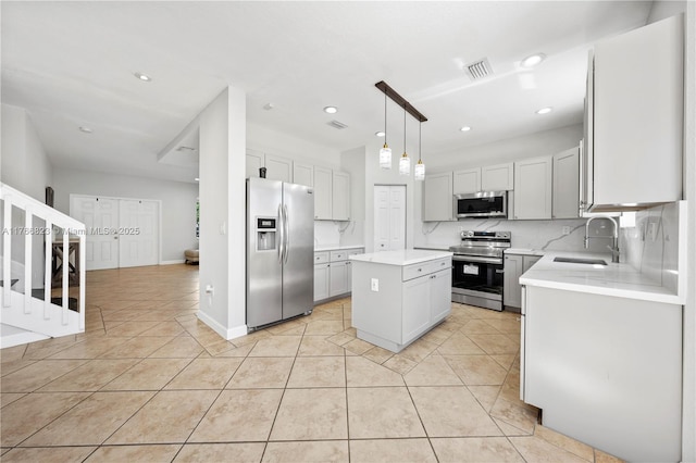 kitchen featuring visible vents, a sink, stainless steel appliances, light tile patterned floors, and decorative backsplash