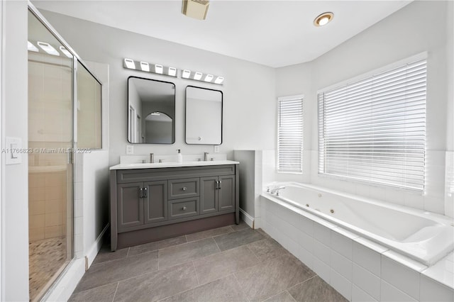 full bath with double vanity, a sink, a stall shower, and a whirlpool tub
