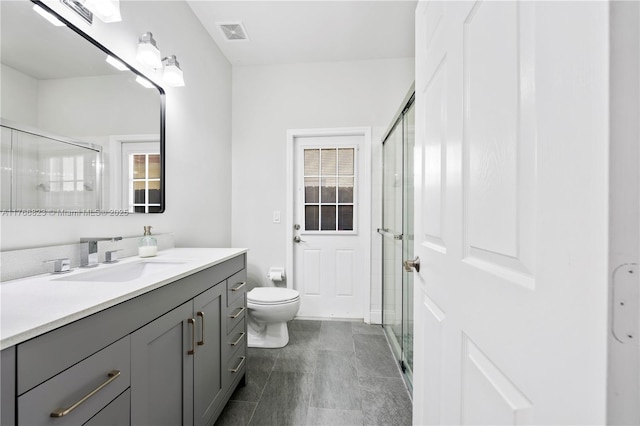 full bathroom with visible vents, toilet, a stall shower, and vanity