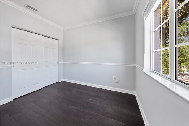 unfurnished bedroom with visible vents, baseboards, dark wood-style floors, and ornamental molding