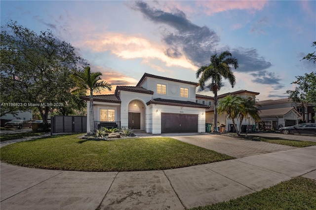 view of front of house featuring stucco siding, a garage, a tiled roof, decorative driveway, and a lawn