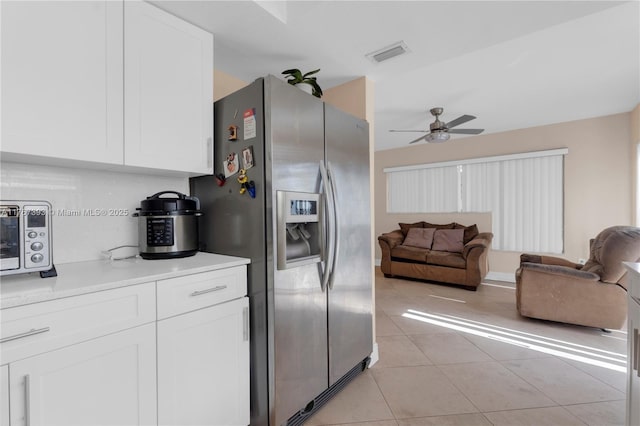 kitchen featuring light tile patterned floors, visible vents, stainless steel fridge with ice dispenser, white cabinetry, and open floor plan