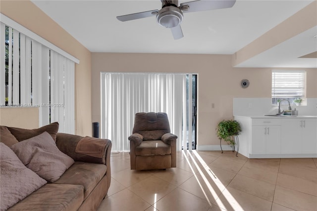 living room with light tile patterned floors, baseboards, and ceiling fan