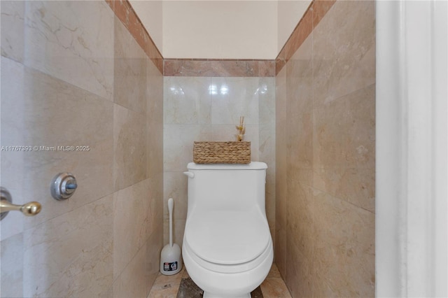 bathroom featuring tile walls and toilet