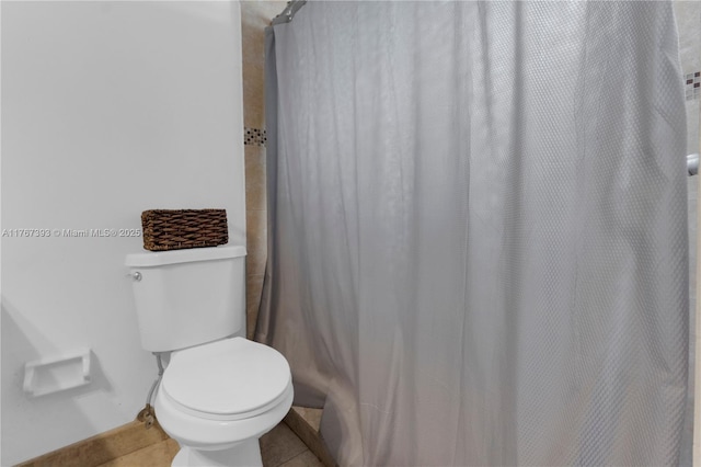 full bathroom featuring tile patterned floors, a shower with curtain, and toilet