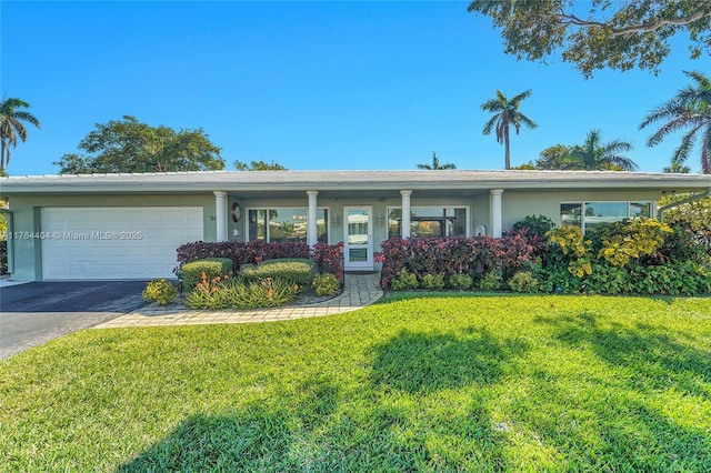 1431 S Ocean Blvd, Lauderdale By The Sea, FL 33062 - single story home with stucco siding, an attached garage, a front yard, and aphalt driveway