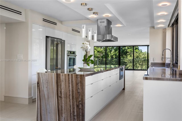 700 Coral Way Unit 2, Coral Gables, FL 33134 - kitchen with appliances with stainless steel finishes, modern cabinets, island exhaust hood, a sink, and white cabinets