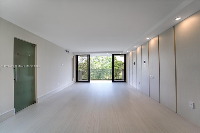 700 Coral Way Unit 2, Coral Gables, FL 33134 - empty room featuring expansive windows, light wood-type flooring, and recessed lighting