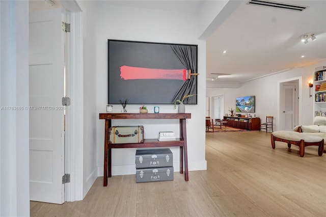 corridor featuring baseboards, visible vents, and wood finished floors