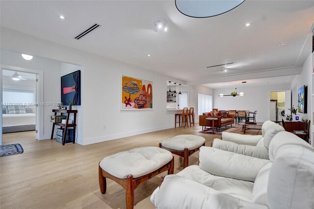 living room with recessed lighting, baseboards, light wood-style floors, and visible vents