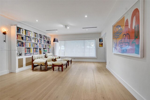 living area with baseboards, recessed lighting, and light wood finished floors