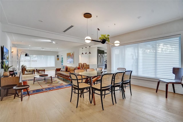 dining area featuring visible vents and light wood-style flooring