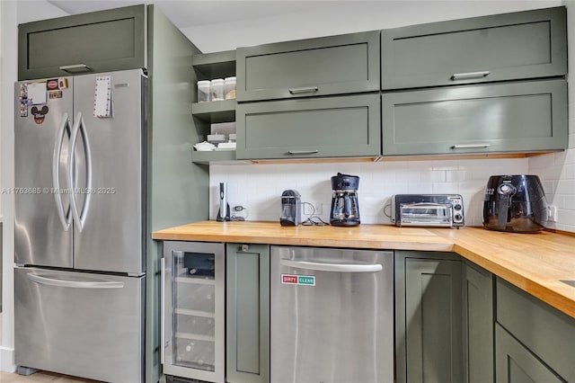 kitchen with freestanding refrigerator, decorative backsplash, wine cooler, and butcher block counters