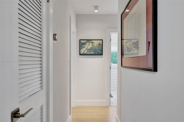 corridor featuring baseboards and light wood-style floors