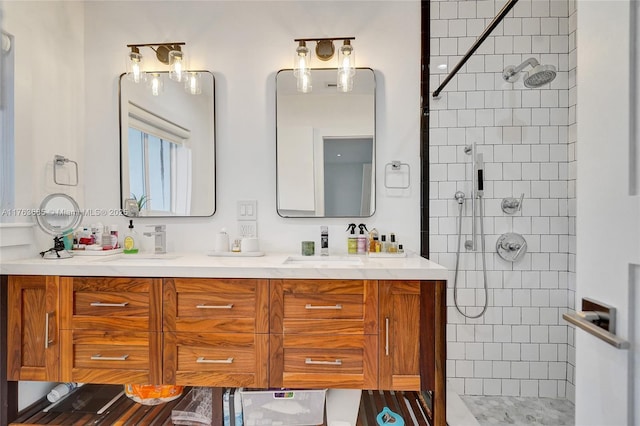 full bath featuring a sink, double vanity, and a tile shower