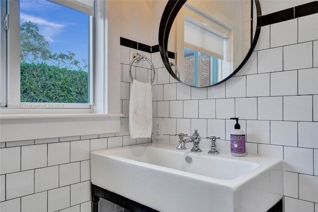 bathroom featuring a sink and tile walls
