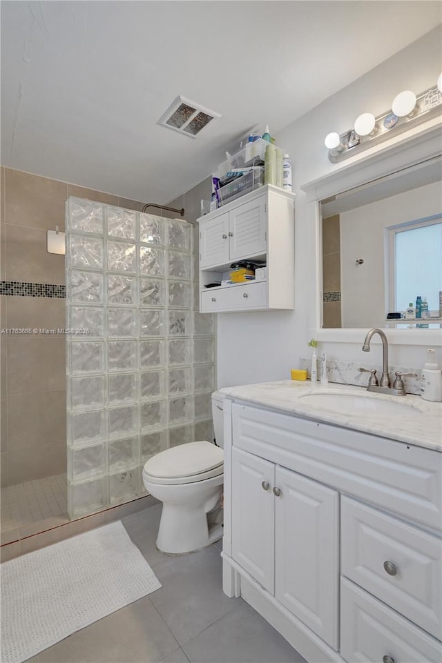 bathroom with toilet, vanity, tile patterned flooring, walk in shower, and visible vents