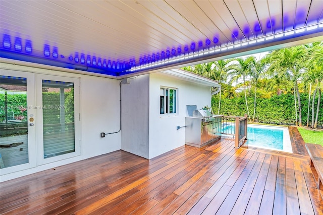 wooden terrace with french doors and an outdoor pool