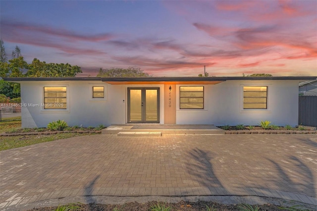 view of front facade with french doors and stucco siding