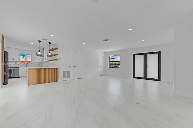 unfurnished living room with recessed lighting, visible vents, a healthy amount of sunlight, and french doors