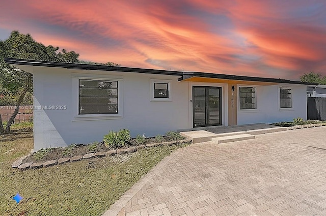 view of front of house featuring stucco siding and fence