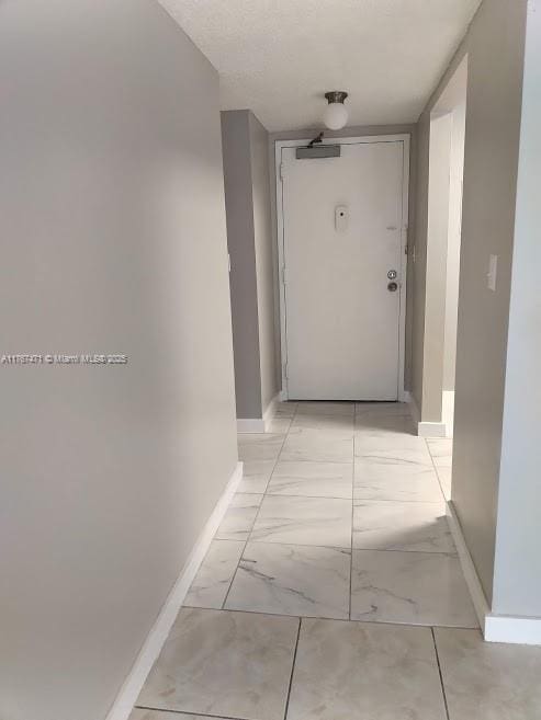 16465 NE 22nd Ave Unit 114, North Miami Beach, FL 33160 - hall featuring marble finish floor and baseboards