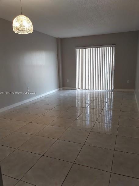 16465 NE 22nd Ave Unit 114, North Miami Beach, FL 33160 - unfurnished room featuring tile patterned floors, baseboards, and a textured ceiling