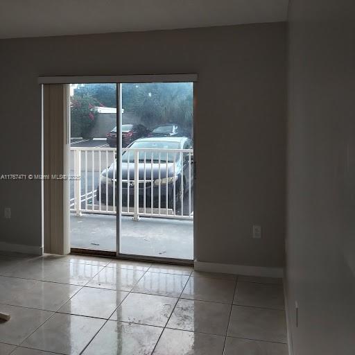 16465 NE 22nd Ave Unit 114, North Miami Beach, FL 33160 - tiled spare room featuring baseboards