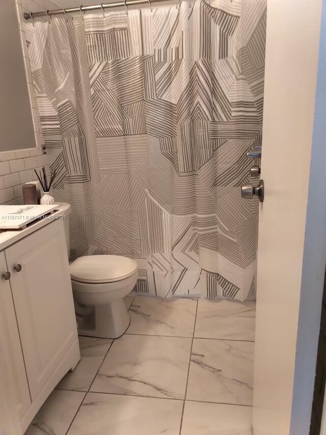 16465 NE 22nd Ave Unit 114, North Miami Beach, FL 33160 - full bath with tile walls, marble finish floor, toilet, curtained shower, and vanity