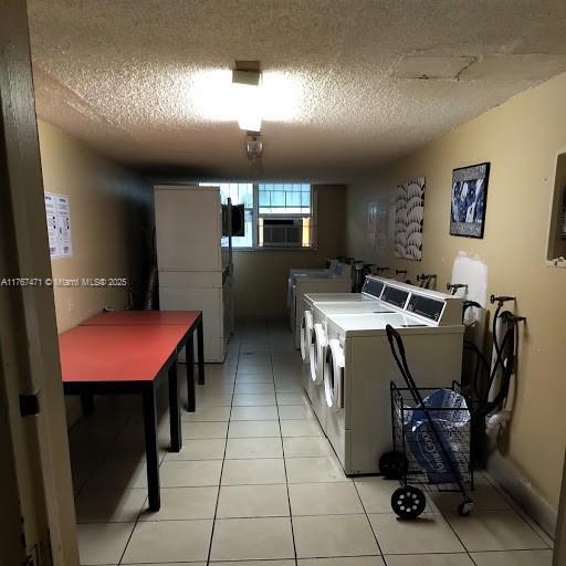 16465 NE 22nd Ave Unit 114, North Miami Beach, FL 33160 - community laundry room with independent washer and dryer, a textured ceiling, and light tile patterned floors
