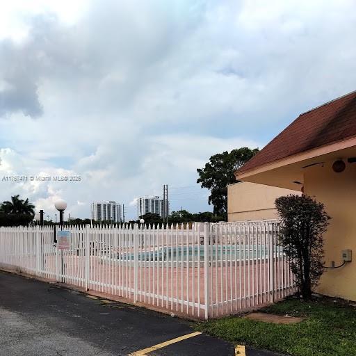 16465 NE 22nd Ave Unit 114, North Miami Beach, FL 33160 - view of gate with a swimming pool and fence