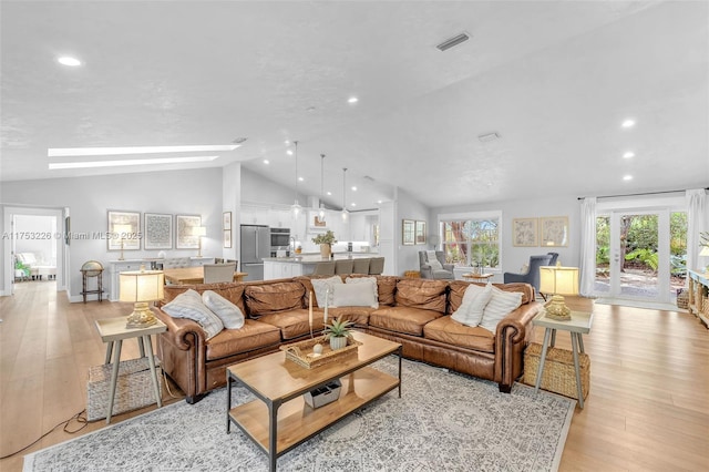 living room featuring light wood finished floors, visible vents, recessed lighting, and vaulted ceiling