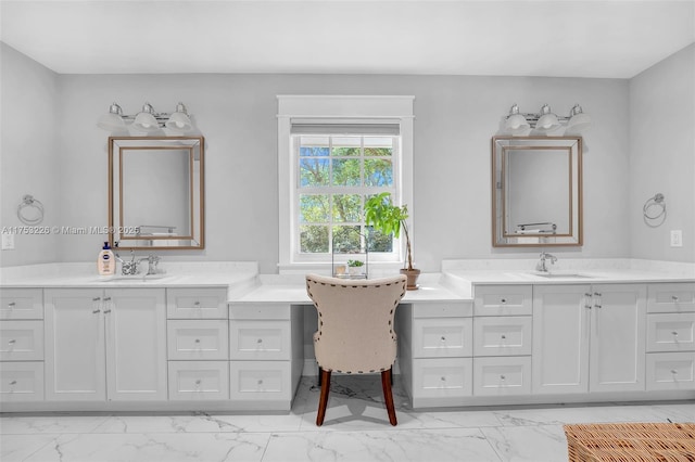 full bath featuring marble finish floor, a sink, and two vanities