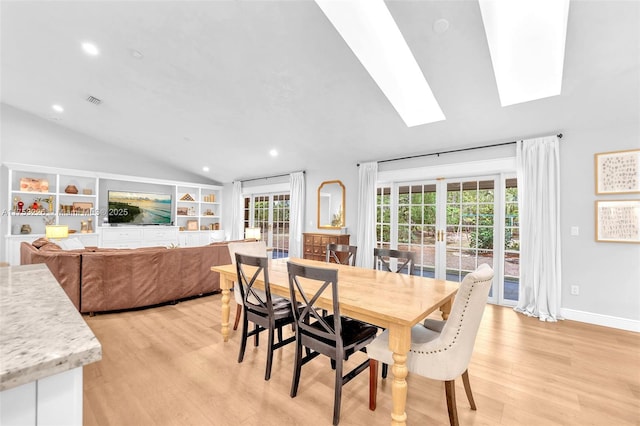 dining area with baseboards, light wood-style flooring, vaulted ceiling with skylight, and recessed lighting