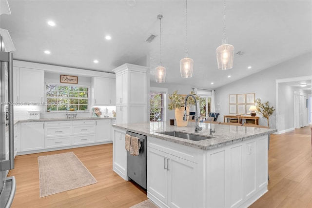 kitchen featuring white cabinets, a kitchen island with sink, a sink, a healthy amount of sunlight, and stainless steel dishwasher