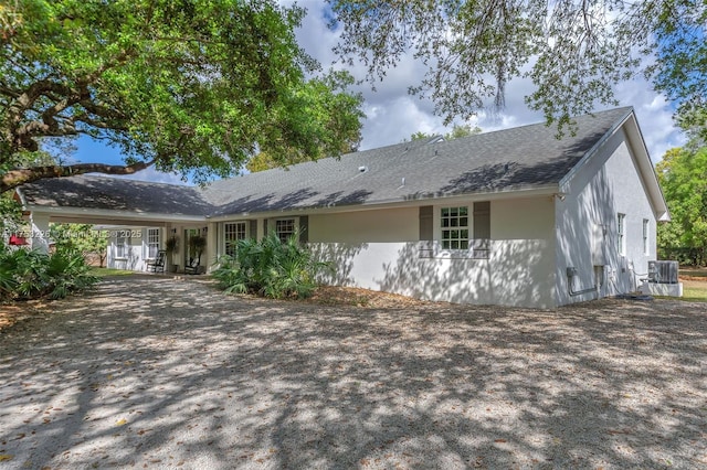 rear view of house featuring stucco siding and central AC