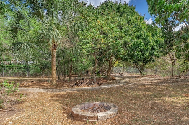 view of yard with fence and an outdoor fire pit