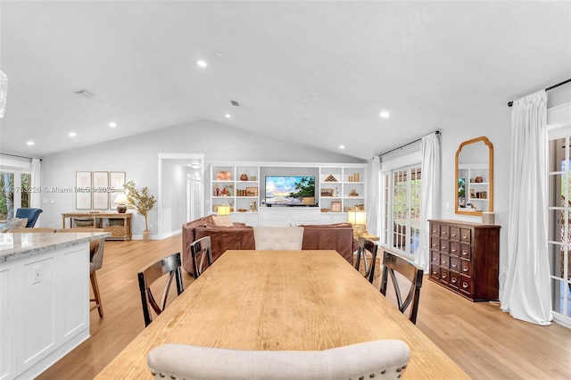 dining space featuring light wood-style floors, lofted ceiling, and a wealth of natural light