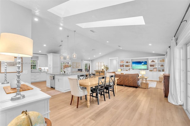 dining space featuring a wealth of natural light, visible vents, lofted ceiling with skylight, and light wood finished floors