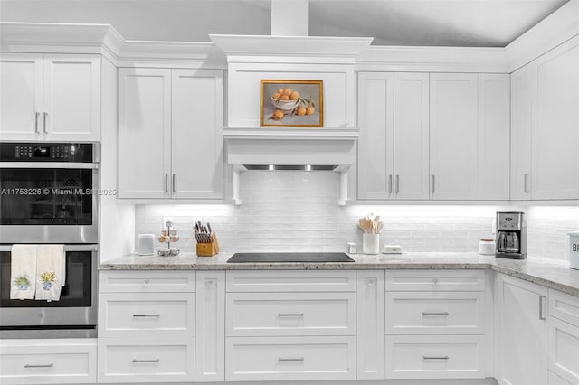 kitchen featuring white cabinetry, stainless steel double oven, black electric stovetop, backsplash, and custom exhaust hood
