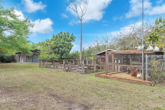 view of yard featuring a vegetable garden, exterior structure, and an outbuilding