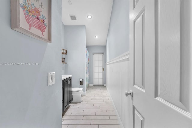 full bathroom featuring toilet, vanity, curtained shower, visible vents, and recessed lighting